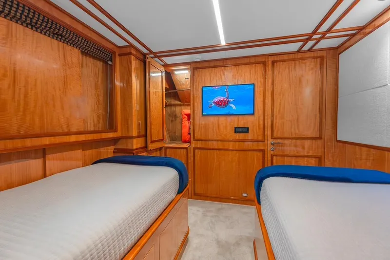 Slide: The Image of Luxurious cabin interior of 2001 Intermarine RPH 95 yacht with twin beds and wooden paneling. - 38