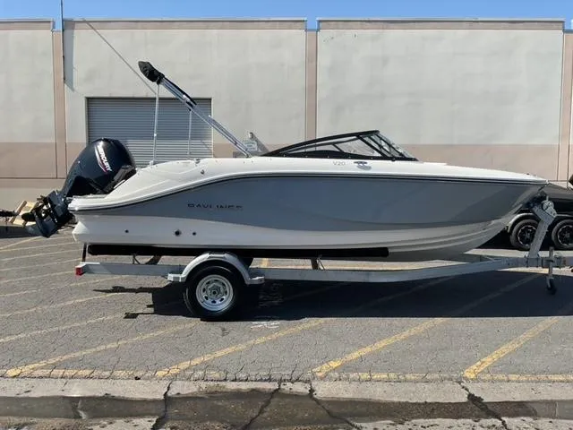 Slide: The Image of 2025 Bayliner V20 boat on trailer, parked in industrial area. - 1