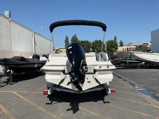 Slide: The Image of 2025 Bayliner V20 boat with outboard motor, parked in a marina lot. - 3