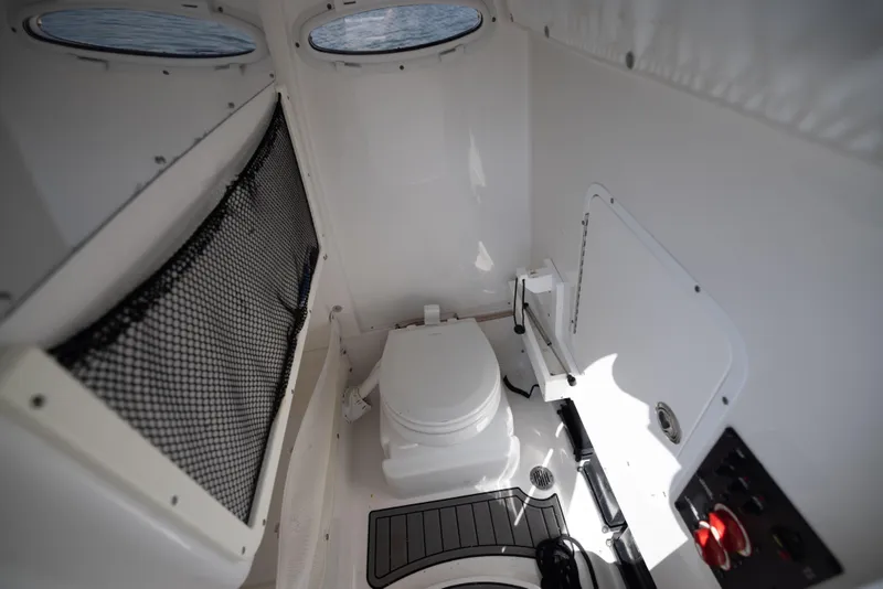 Slide: The Image of 2020 Sea Hunt GAMEFISH boat interior with marine toilet and storage netting. - 11