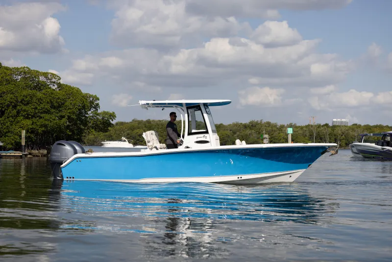 Slide: The Image of 2020 Sea Hunt GAMEFISH boat on calm water under a partly cloudy sky. - 3