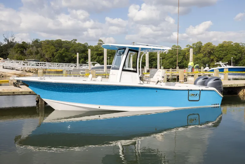 Slide: The Image of 2020 Sea Hunt GAMEFISH boat docked in a marina, featuring a sleek blue and white design. - 4