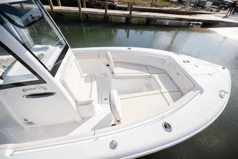 Slide: The Image of 2020 Sea Hunt GAMEFISH boat with spacious seating, docked by calm waters. - 6