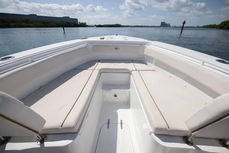 Slide: The Image of 2020 Sea Hunt GAMEFISH boat interior with white seating, on a calm waterway. - 7