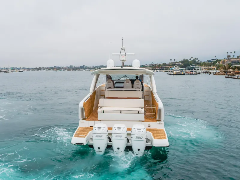 Slide: The Image of 2024 Jeanneau DB/43 OB yacht cruising on open water, rear view. - 2
