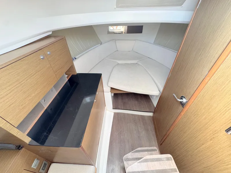 Slide: The Image of 2018 Jeanneau Leader 9.0 WA cabin interior with wood finish and cozy seating area. - 12