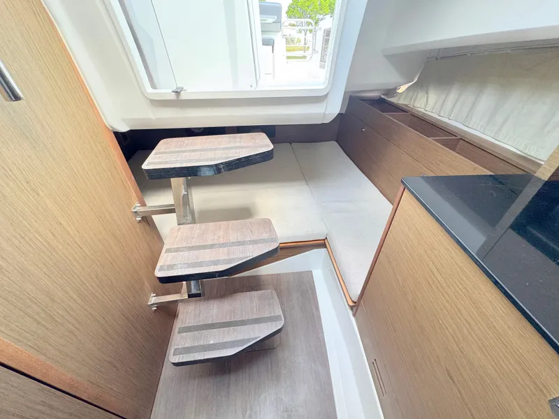Slide: The Image of Interior of 2018 Jeanneau Leader 9.0 WA boat with wooden steps and seating area. - 15