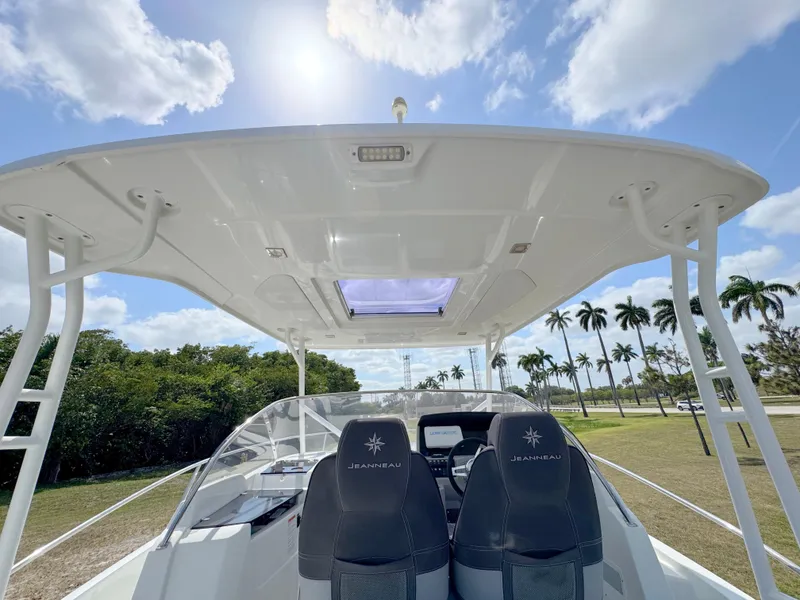 Slide: The Image of 2018 Jeanneau Leader 9.0 WA boat interior with helm seats, under a sunny sky. - 37