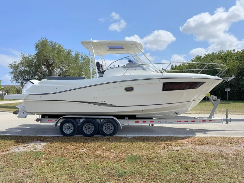 Slide: The Image of 2018 Jeanneau Leader 9.0 WA boat on a trailer, parked outdoors. - 6