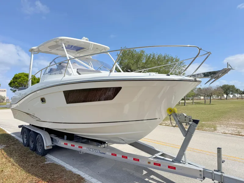 Slide: The Image of 2018 Jeanneau Leader 9.0 WA boat on trailer, parked outdoors under blue sky. - 7