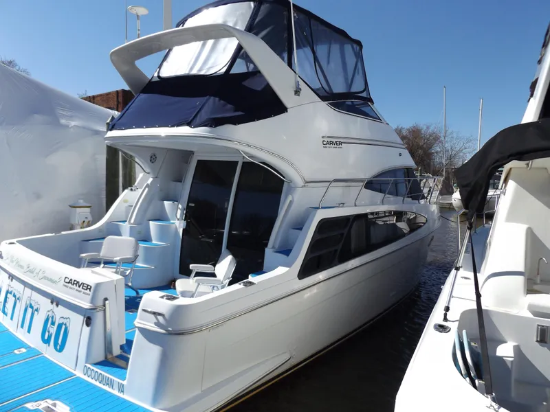 Slide: The Image of 2003 Carver 360 Sport Sedan yacht docked, featuring sleek design and spacious upper deck. - 1