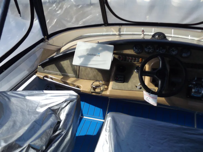 Slide: The Image of 2003 Carver 360 Sport Sedan cockpit with Garmin navigation, blue flooring, and covered seats. - 19