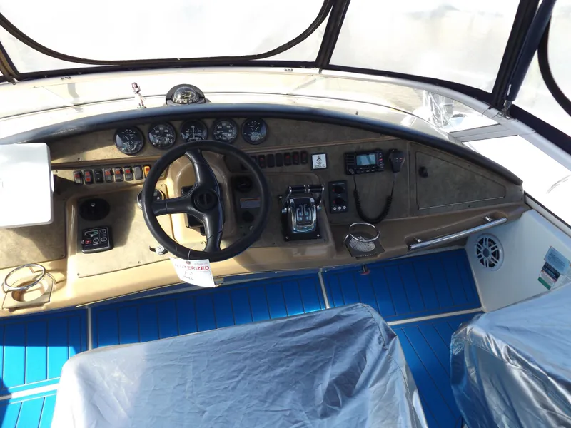 Slide: The Image of 2003 Carver 360 Sport Sedan cockpit with steering wheel, gauges, and blue flooring. - 20