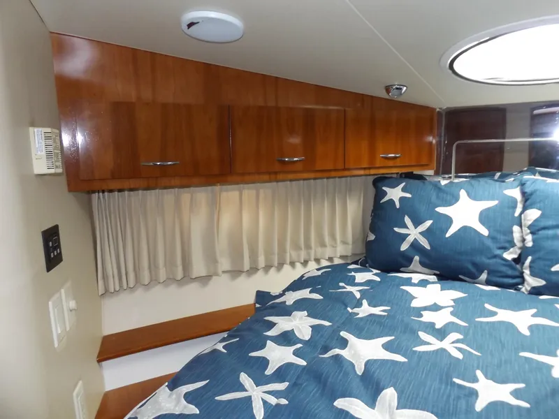 Slide: The Image of Interior of 2003 Carver 360 Sport Sedan with starfish bedding and wooden cabinets. - 29