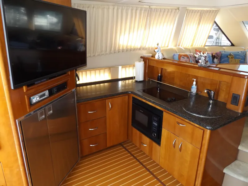 Slide: The Image of 2003 Carver 360 Sport Sedan kitchen with wood cabinetry, microwave, and TV. - 35