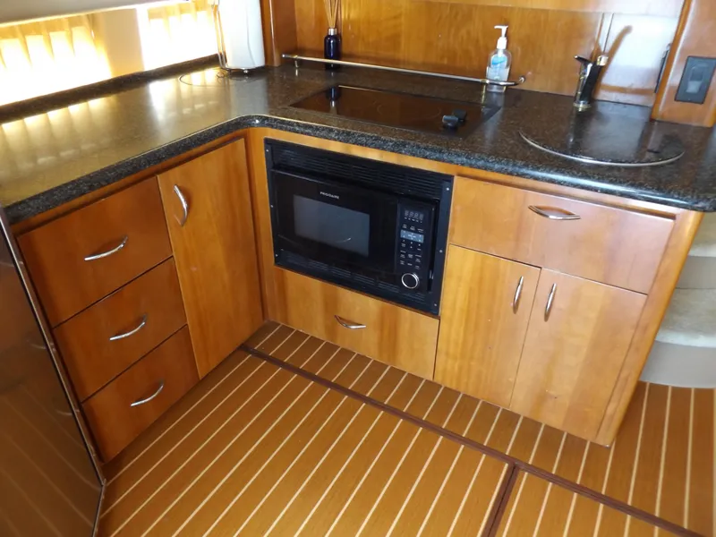 Slide: The Image of 2003 Carver 360 Sport Sedan kitchen with wood cabinetry, microwave, and sleek countertops. - 36