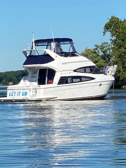 Slide: The Image of 2003 Carver 360 Sport Sedan yacht on a serene lake with clear blue skies. - 42