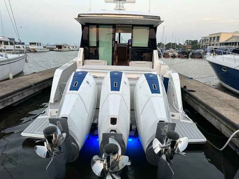 Slide: The Image of 2024 Tiara Yachts 48 LE with triple outboard engines docked at marina. - 15