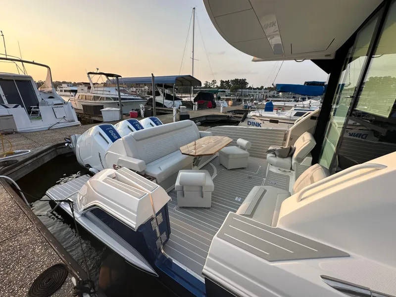 Slide: The Image of 2024 Tiara Yachts 48 LE with spacious deck and seating at marina during sunset. - 3