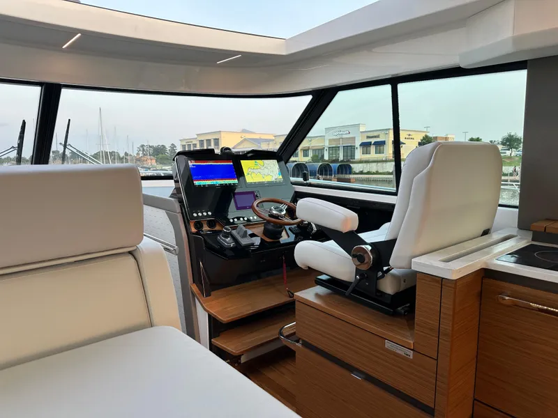 Slide: The Image of 2024 Tiara Yachts 48 LE helm with modern navigation systems and luxurious seating. - 8