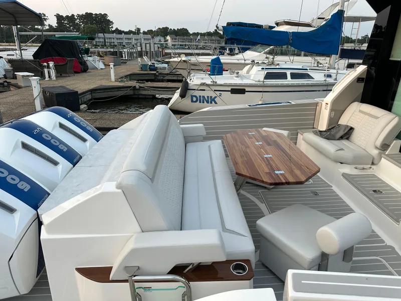 Slide: The Image of 2024 Tiara Yachts 48 LE luxury boat with seating and table at marina. - 9