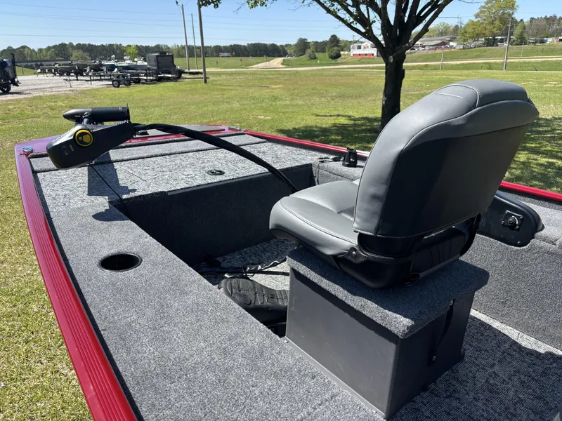 Slide: The Image of 2025 Tracker Panfish 17 boat interior with gray seating and trolling motor, parked on grass. - 10