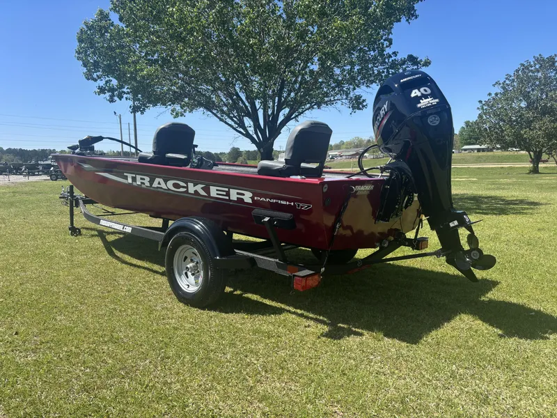 Slide: The Image of 2025 Tracker Panfish 17 boat on trailer, parked on grass under a tree. - 6
