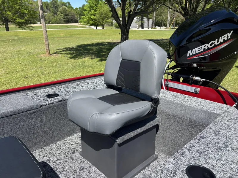 Slide: The Image of 2025 Tracker Panfish 17 boat seat with Mercury engine in a grassy park setting. - 8