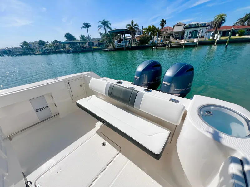 Slide: The Image of 2022 Robalo R272 Center Console boat with twin engines, docked by waterfront homes. - 10