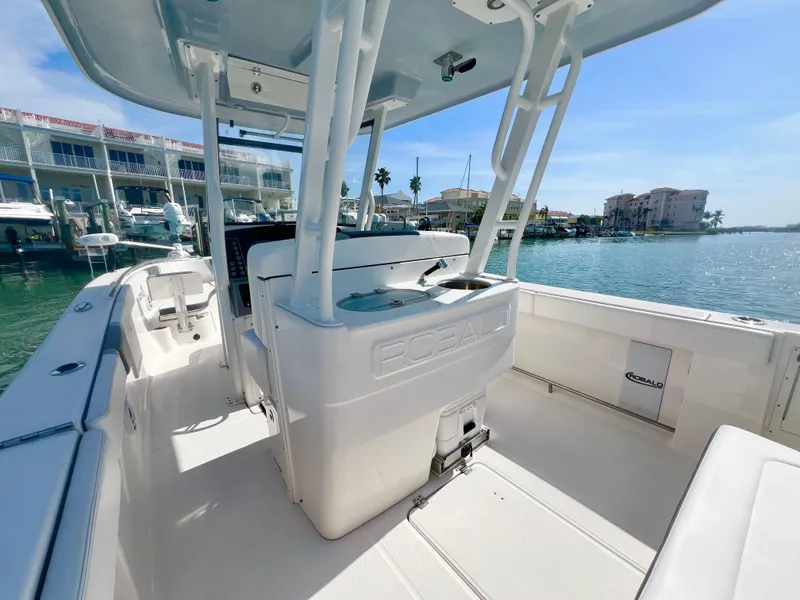 Slide: The Image of 2022 Robalo R272 Center Console boat docked in a marina under clear skies. - 12