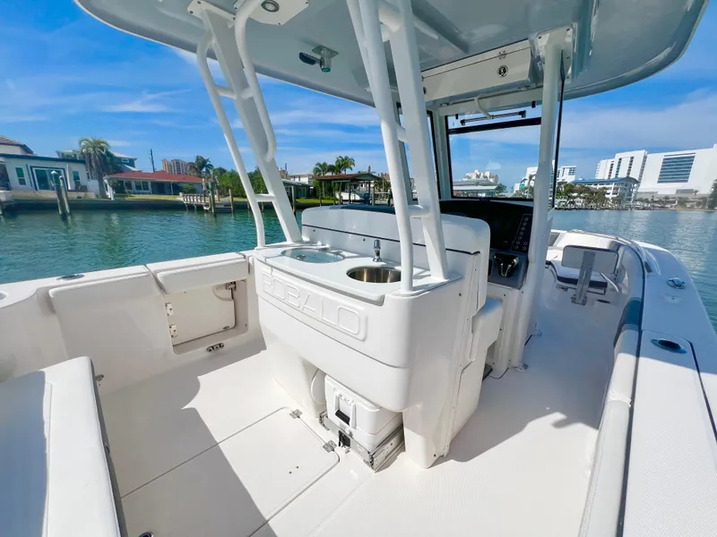 Slide: The Image of 2022 Robalo R272 Center Console boat with sleek design, docked near waterfront homes. - 13