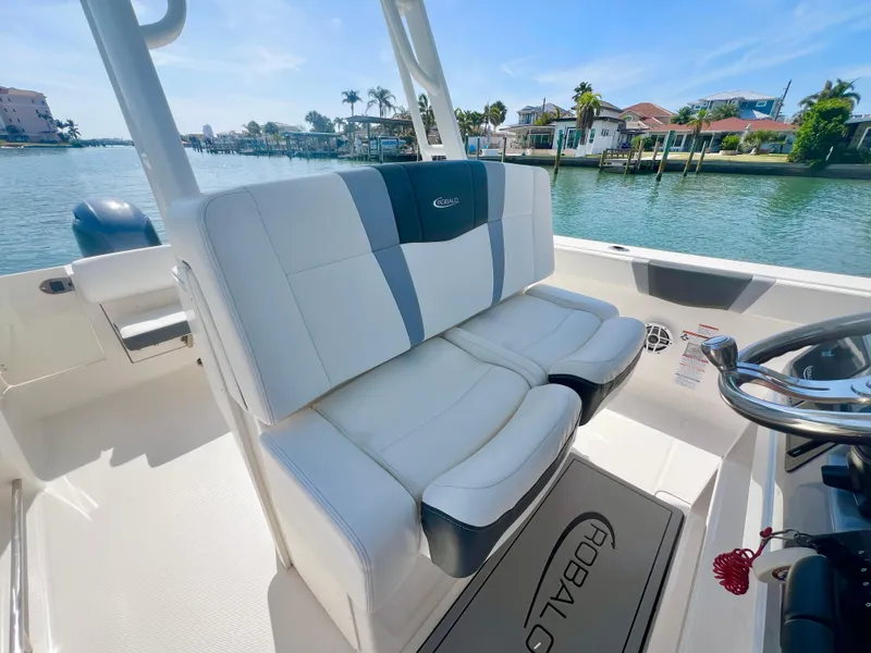 Slide: The Image of 2022 Robalo R272 Center Console boat interior with plush seating, dockside view. - 15