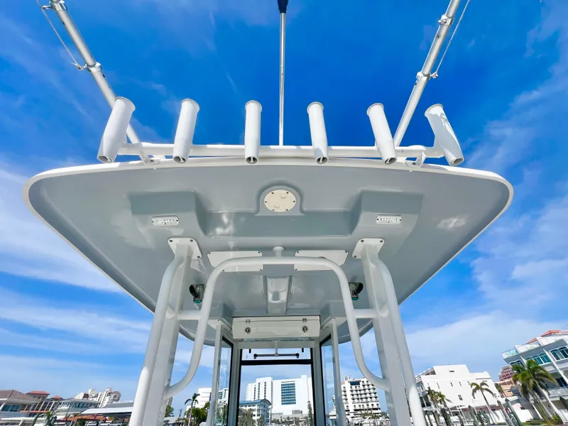 Slide: The Image of 2022 Robalo R272 Center Console boat with rod holders against a clear blue sky. - 18