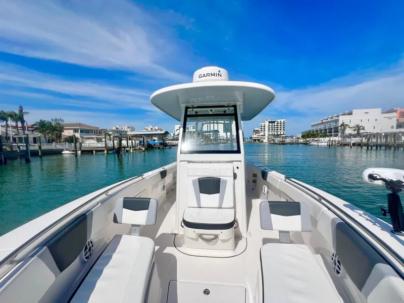 Slide: The Image of 2022 Robalo R272 Center Console boat docked in a scenic marina. - 19