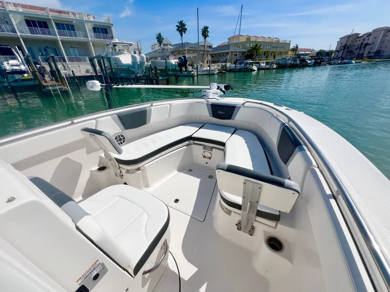 Slide: The Image of 2022 Robalo R272 Center Console boat with spacious seating, docked in a sunny marina. - 21