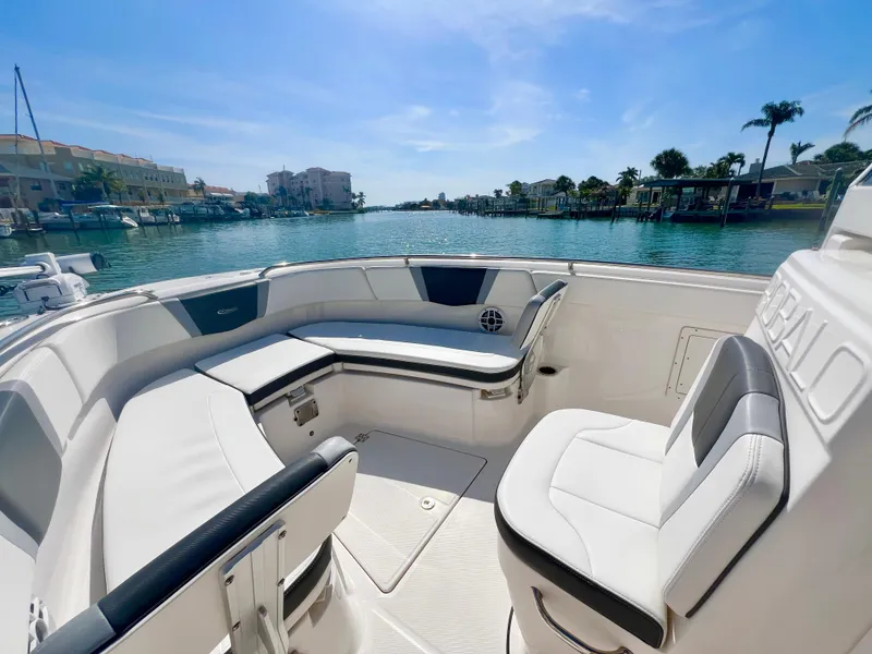 Slide: The Image of 2022 Robalo R272 Center Console boat interior with seating, overlooking a scenic waterfront. - 22