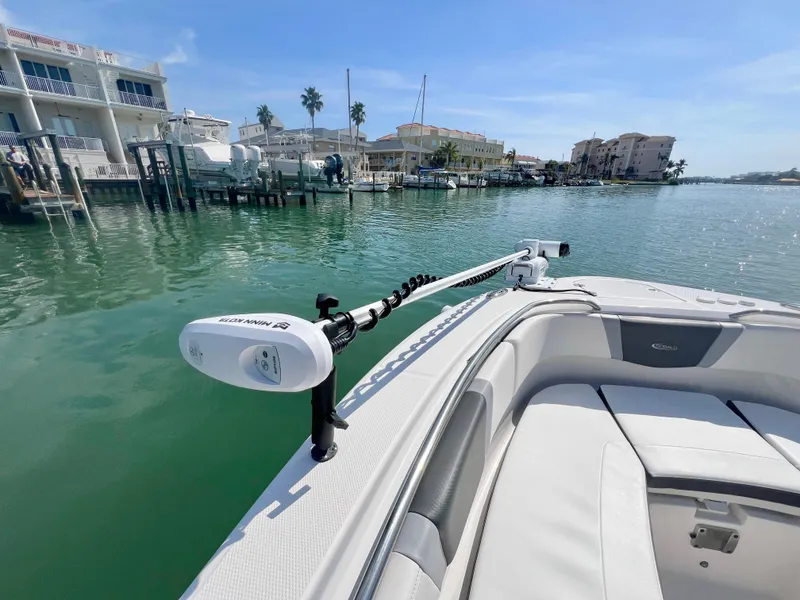 Slide: The Image of 2022 Robalo R272 Center Console boat docked in a scenic marina setting. - 27