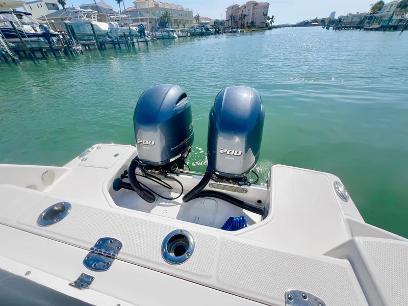 Slide: The Image of 2022 Robalo R272 Center Console with dual 200 horsepower engines on a calm waterway. - 8
