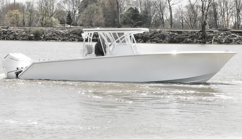 Slide: The Image of 2024 SeaHunter 35 Tournament boat cruising on a calm river with trees in the background. - 11