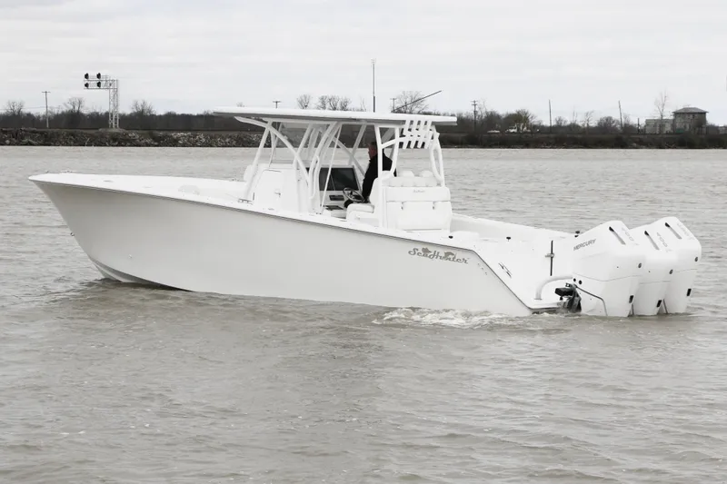 Slide: The Image of 2024 SeaHunter 35 Tournament boat on water, featuring sleek design and triple outboard engines. - 7