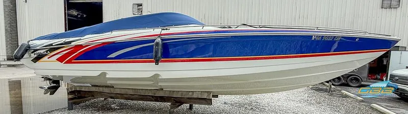 Slide: The Image of 2008 Formula 292 FASTech speedboat with blue, red, and white design, docked on a stand. - 12