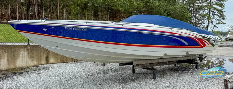 Slide: The Image of 2008 Formula 292 FASTech boat with blue and red accents, parked on gravel. - 13