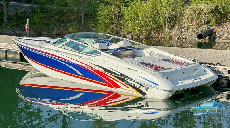 Slide: The Image of 2008 Formula 292 FASTech boat with vibrant graphics docked on calm water. - 2