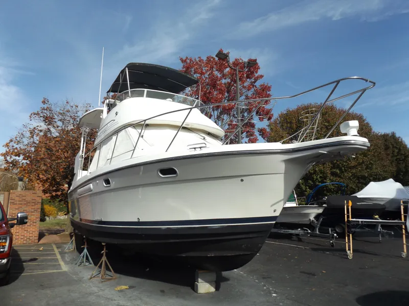The Image of 2000 Bayliner 4087 Aft Cabin Motoryacht on dry dock, surrounded by autumn trees. - 0