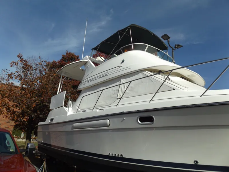 Slide: The Image of 2000 Bayliner 4087 Aft Cabin Motoryacht with white exterior, docked under clear blue sky. - 2