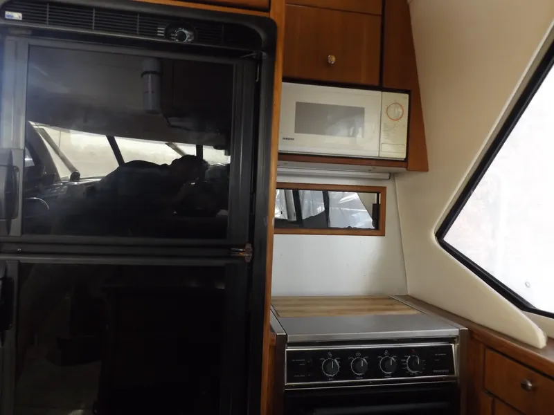 Slide: The Image of Bayliner 4087 Aft Cabin Motoryacht 2000 kitchen with stove, microwave, and refrigerator. - 20