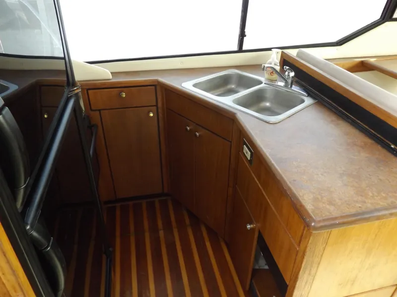 Slide: The Image of 2000 Bayliner 4087 Aft Cabin Motoryacht kitchen with wooden cabinets and dual sink. - 21