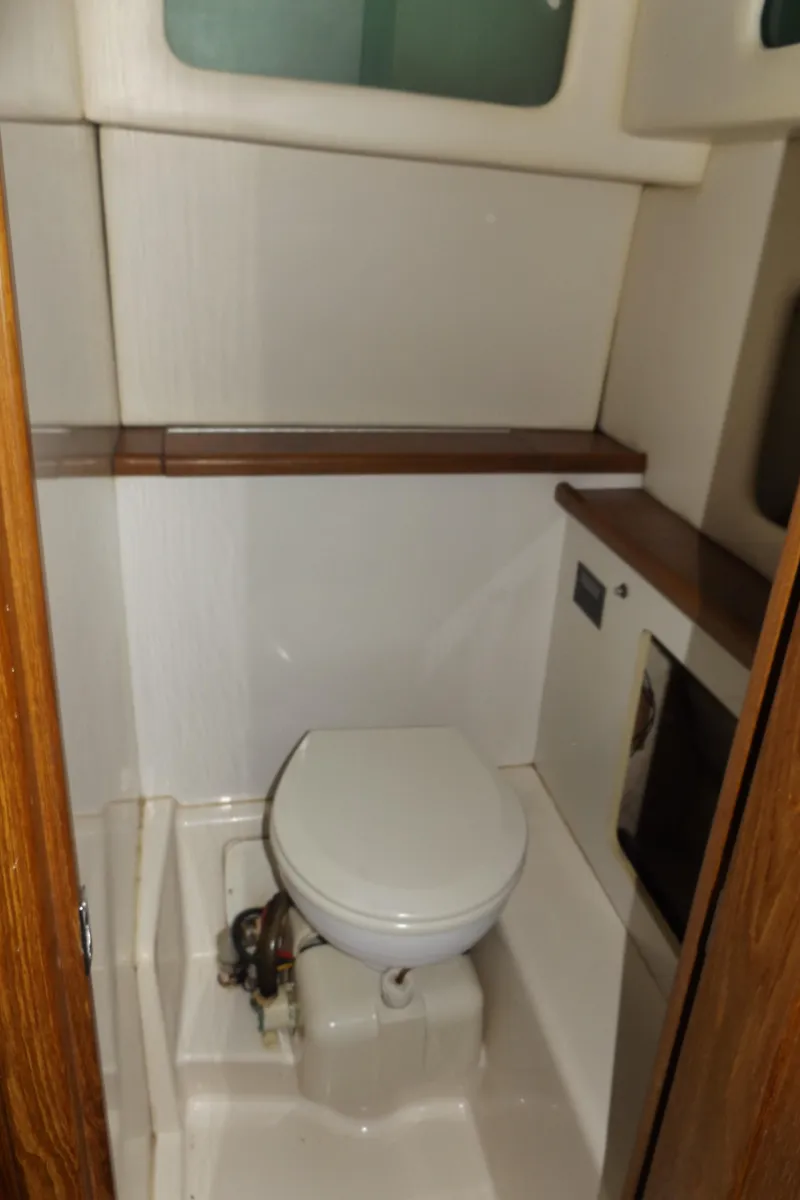 Slide: The Image of 2000 Bayliner 4087 Aft Cabin Motoryacht bathroom with toilet and wooden accents. - 30