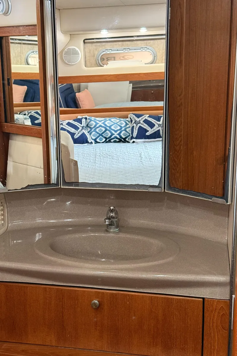 Slide: The Image of Bayliner 4087 Aft Cabin Motoryacht 2000 bathroom with sink and mirror reflecting cabin interior. - 33