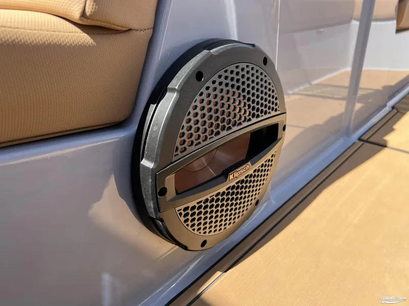 Slide: The Image of 2025 MasterCraft NXT24 boat with Klipsch speaker, beige seating, and sleek design. - 14